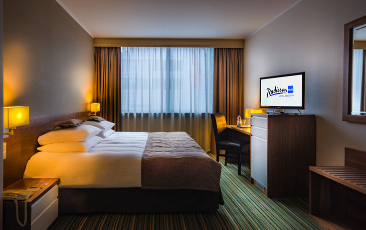 Standard Hotelzimmer mit Doppelbett, Schreibtisch und Fernseher im Radisson BLU Stettin