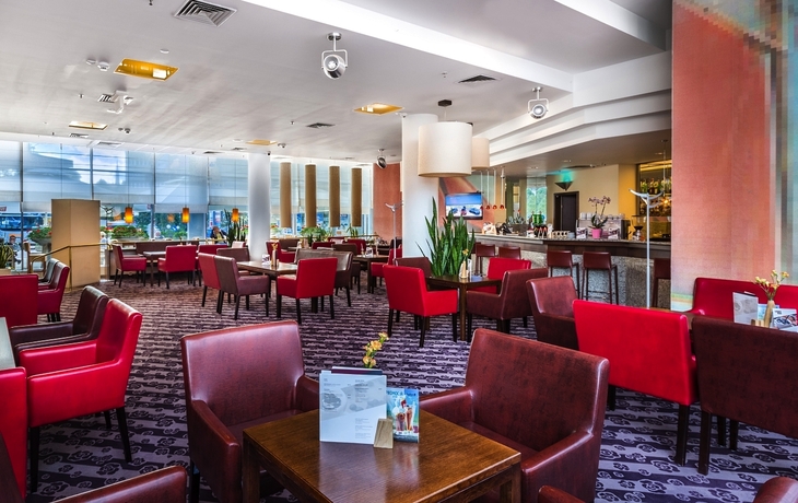 Hotel-Lobbybar mit roten Stühlen und modernen Dekorelementen im Radisson BLU Stettin.