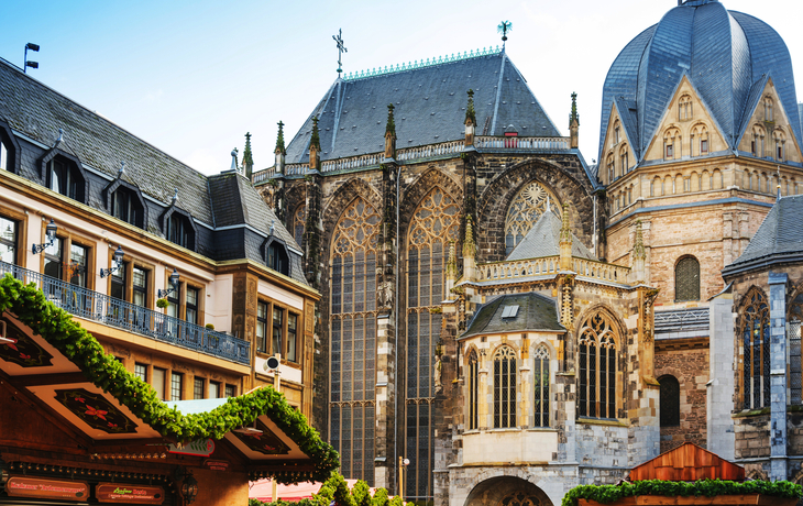 Historische Kirche mit Weihnachtsmarktständen im Vordergrund.