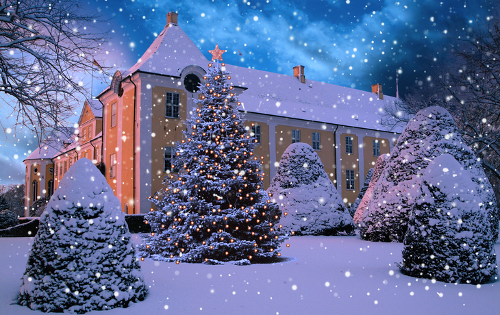 Schloss Gavnø im Schnee mit Weihnachtsbaum und winterlicher Beleuchtung.