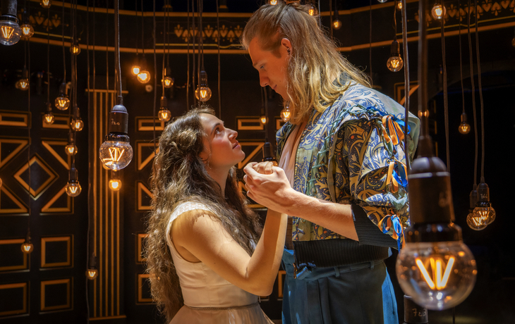 Romeo und Julia - Das Musical© Jörn Hartmann Paar in Kostümen auf einer Bühne unter warmem Licht.