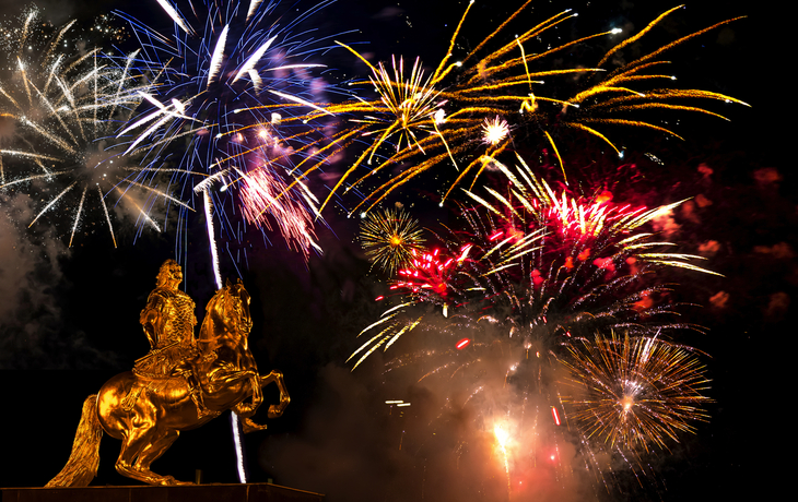 Goldene Reiterstatue vor Feuerwerk am Nachthimmel