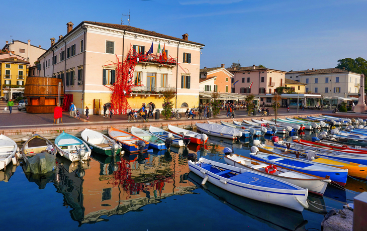 Hafen von Bardolino am Gardasee mit Booten und Promenade im Hintergrund.
