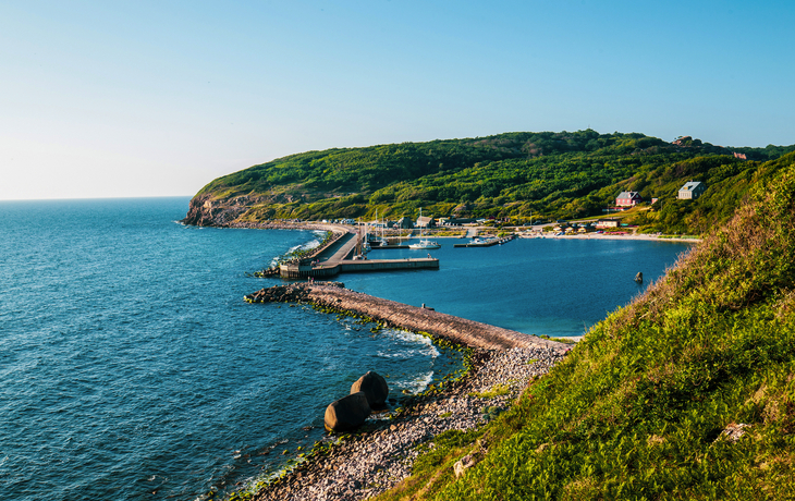 Hammerhavn Jachthafen auf Bornholm, umgeben von grünen Hügeln und blauem Meer.
