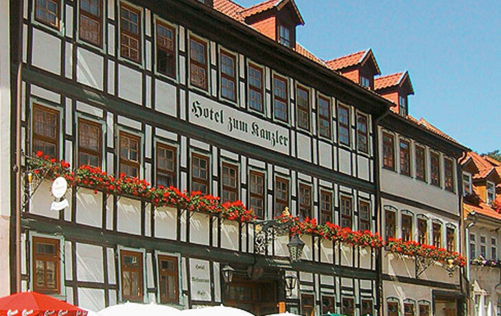 Fachwerkhaus des Hotel Zum Kanzler mit Straßencafé bei sonnigem Wetter.