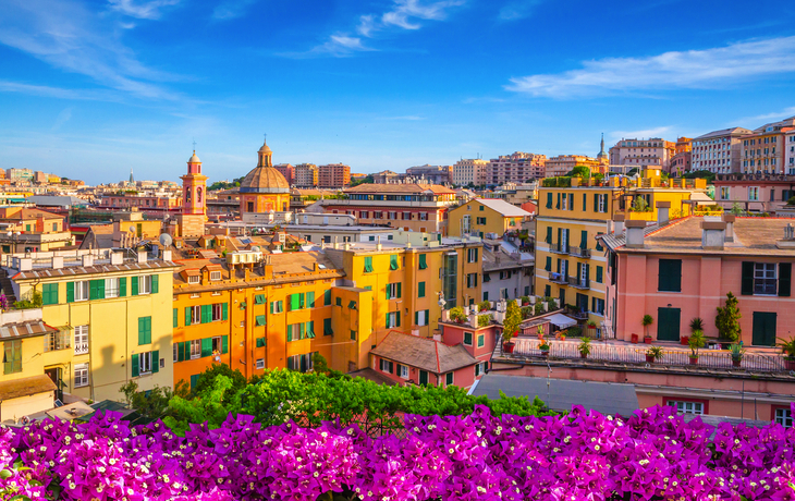 Panoramablick auf die Hafenstadt Genua in Ligurien, Italien, mit bunten Gebäuden und blauem Himmel.