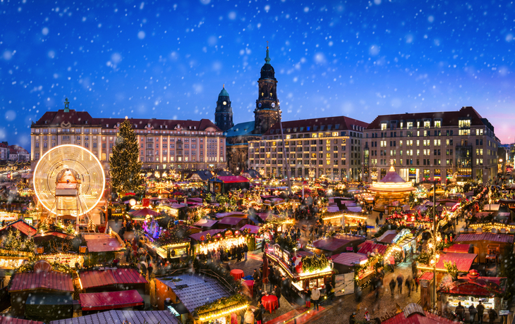 Striezelmarkt in Dresden mit Lichtern, Weihnachtsbaum und Menschen, winterliche Atmosphäre.