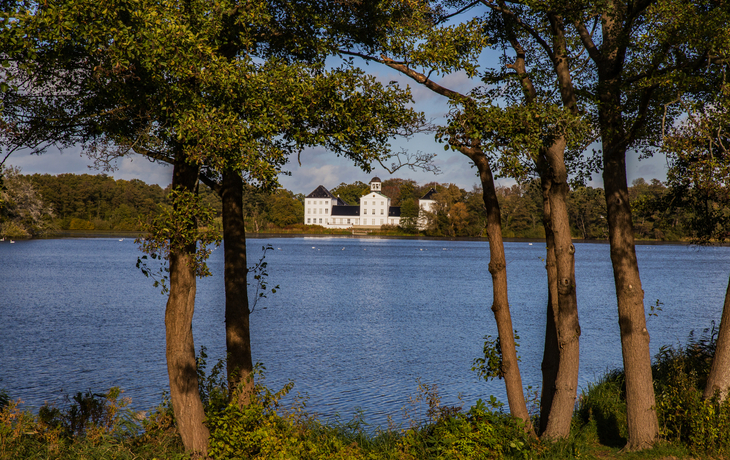 Schloss Gravenstein in Dänemark, umgeben von Bäumen und gelegen an der Flensburger Förde.