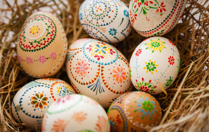 Bunte, dekorierte Ostereier in einem Nest aus Stroh.