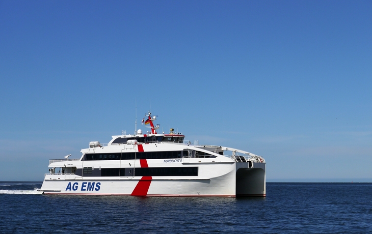 Katamaran Nordlicht II fährt auf ruhiger See unter klarem Himmel.