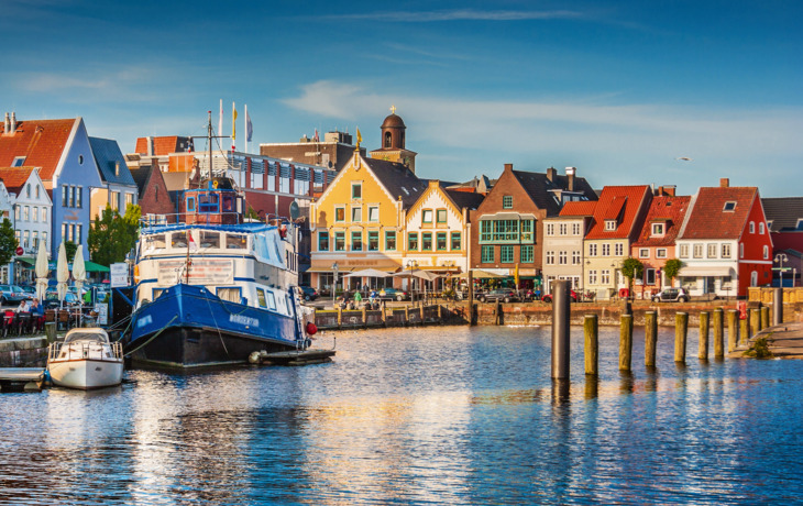 Städtischer Hafen mit bunten Gebäuden und Booten im Wasser.