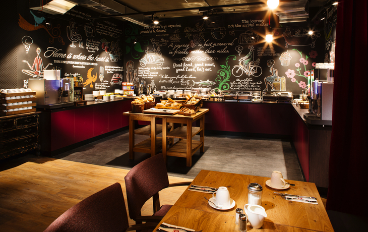 Frühstücksbereich mit Tisch und Frühstücksbuffet im Penta Hotel Wiesbaden.