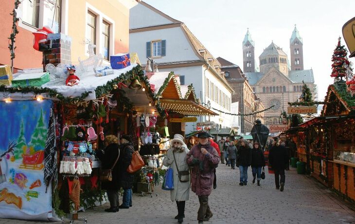 Besucher schlendern über den Weihnachtsmarkt in der Altstadt mit Ständen und Dekorationen.
