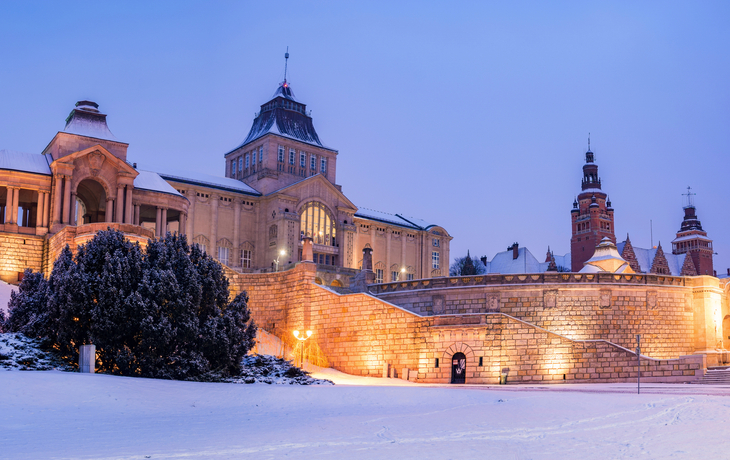Schneebedecktes Gebäude in Stettin bei Dämmerung mit blauer Winterlandschaft.