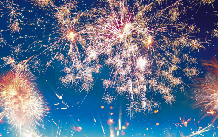 Feuerwerk vor einem klaren Nachthimmel mit farbenfrohen, funkelnden Lichtexplosionen.