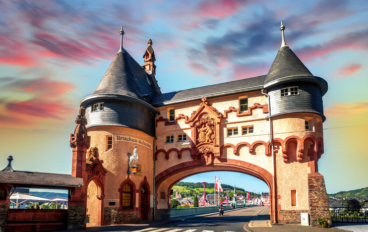 Historisches Stadttor mit Türmen bei Sonnenuntergang.