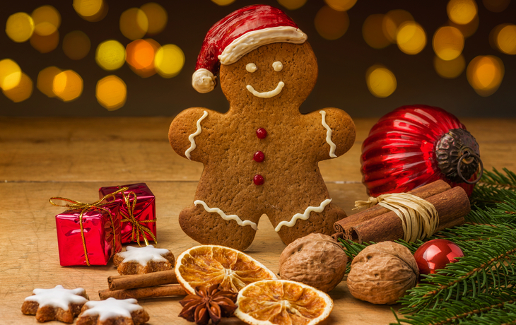 Lebkuchenmann mit Zimt, Nüssen und Weihnachtsdekoration.