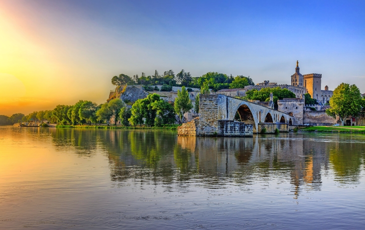 Pont Saint-Bénézet in Avignon über der Rhône im Sonnenuntergang mit Papstpalast im Hintergrund