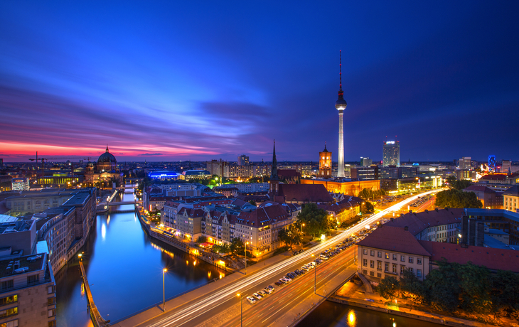 Skyline von Berlin bei Abenddämmerung mit beleuchtetem Fernsehturm und Berliner Dom.