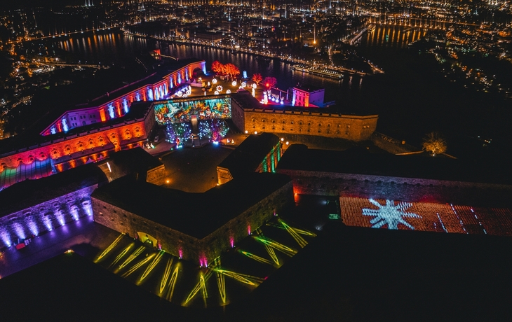 Luftaufnahme der beleuchteten Festung Ehrenbreitstein bei Nacht während des Christmas Gardens.