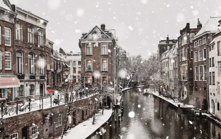 Kanal in Utrecht im Winter mit verschneiten Grachtenhäusern