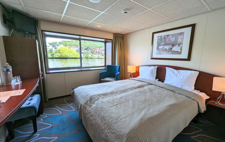2-Bett-Kabine auf einem Schiff mit Blick aus dem Fenster.