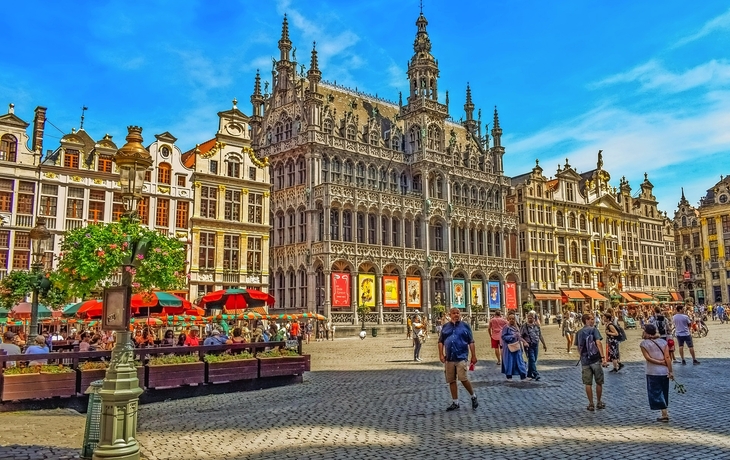 Grand Place in Brüssel mit historischen Gebäuden und Menschen auf dem Marktplatz.