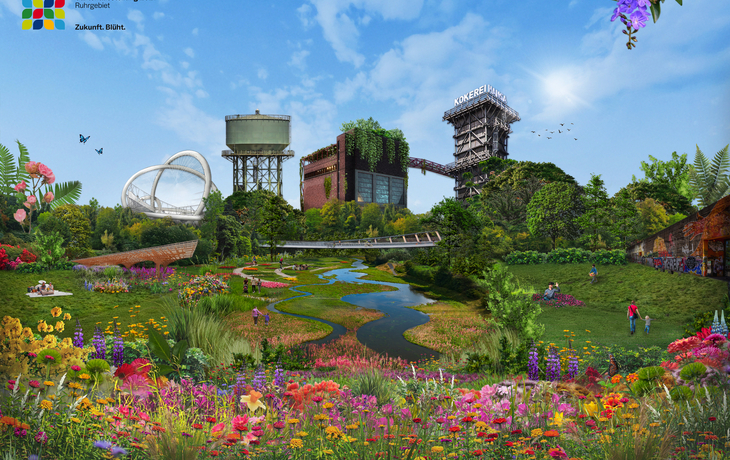 Blühende Gartenschau mit historischen Gebäuden und Wiesen im Hintergrund.