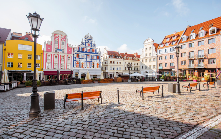 Marktplatz in Stettin, Polen, mit bunten Gebäuden und Kopfsteinpflaster.