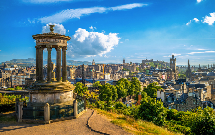 Blick auf Edinburgh von Calton Hill, mit historischen Gebäuden und Hügeln im Hintergrund.