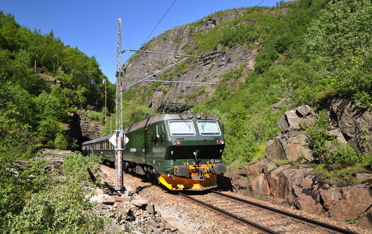 Flåmsbana-Zug in norwegischer Berglandschaft auf Schmalspurbahn.
