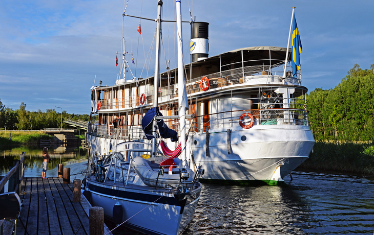 Ausflugsdampfer und Segelboot auf dem Göta-Kanal in Schweden.