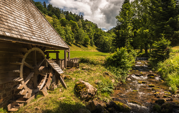 Hilzingermühle im Glottertal mit Bach, Wiesen und bewaldeten Hügeln im Hintergrund