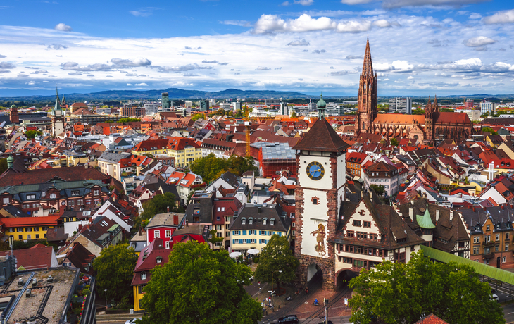 Stadtansicht von Freiburg im Breisgau mit historischem Martinstor und Münster im Hintergrund.