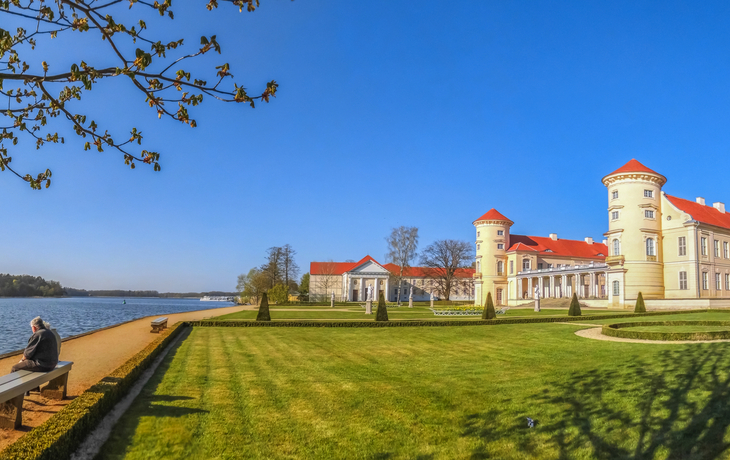 Schloss Rheinsberg am Grienericksee bei sonnigem Wetter.