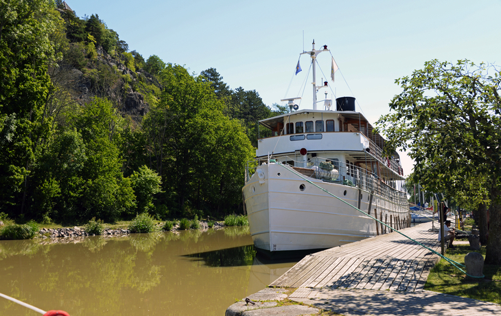 Schiff im Kanal neben einem Wald am sonnigen Tag