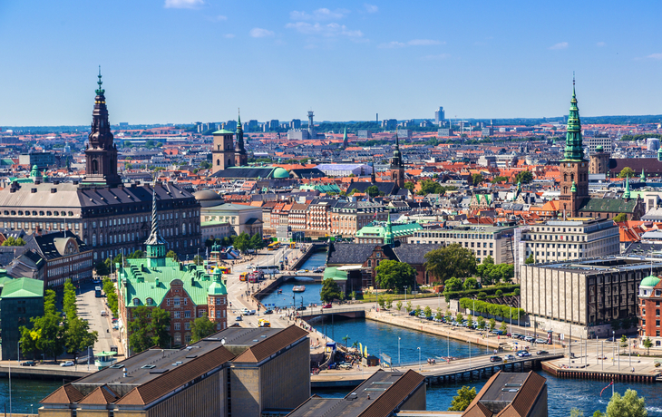 Skyline von Kopenhagen mit Gebäuden und Wasserkanälen bei klarem Himmel.