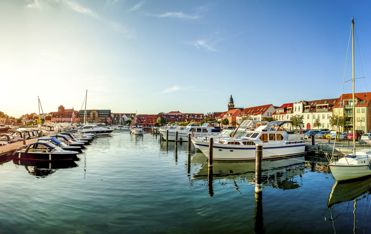Hafen von Waren an der Müritz mit Booten und Gebäuden im Hintergrund.