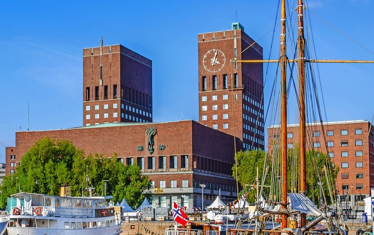 Hafen mit Booten und dem Osloer Rathaus im Hintergrund.
